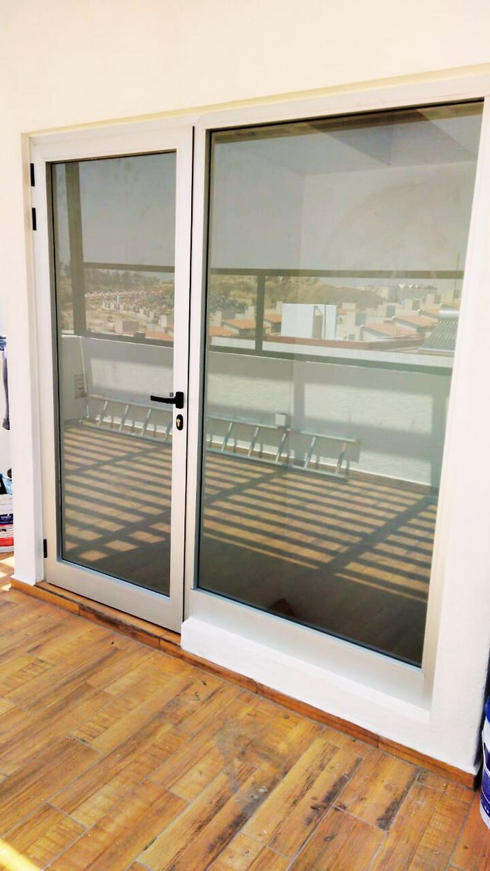 Puerta abatible de aluminio con módulo fijo